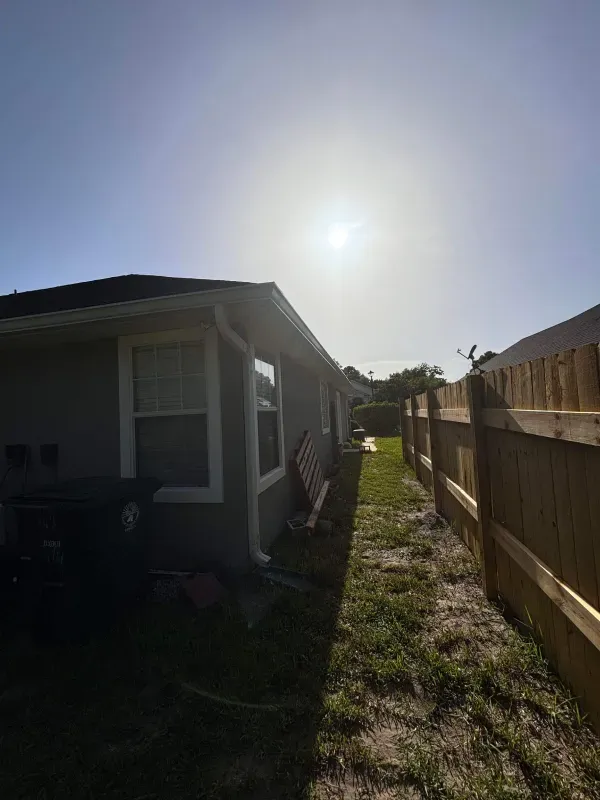 A house with a wooden fence in front of it.