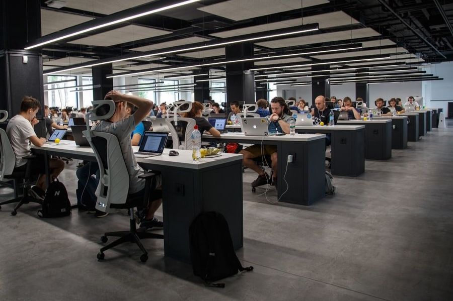 A group of people are sitting at desks in an office.