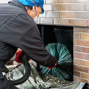 Chimney sweep wearing a mask for protection whilst cleaning chimney - air duct cleaning in Klamath Falls, OR