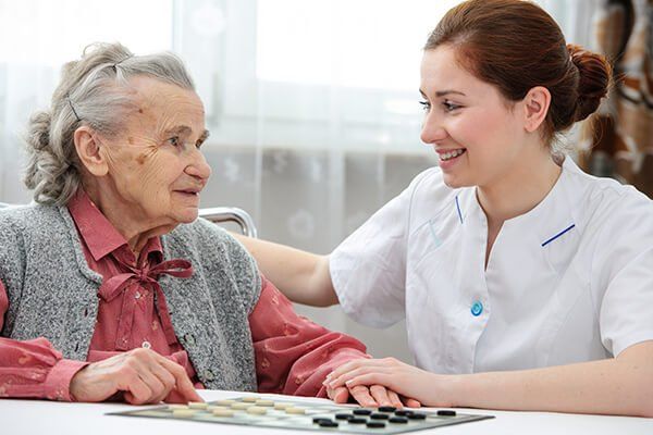 Elderly woman comforted by a carer
