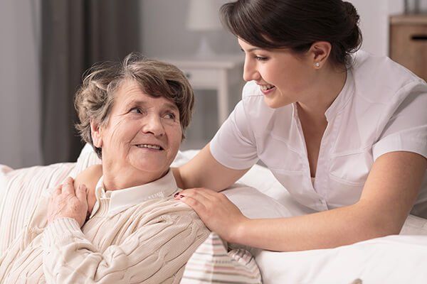 Photo of a carer during work with an elderly woman