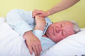 Elderly man being comforted to sleep