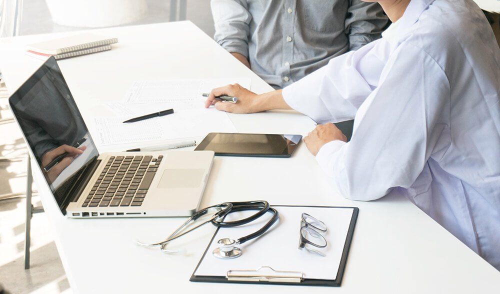 photo of two people sitting at a desk discussing