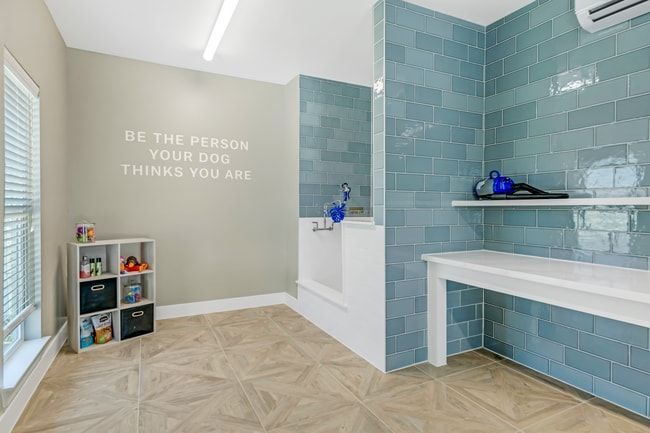A clubhouse with chairs , a table , and a large window at Atlas Bluewood in Celina, TX.
