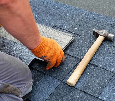 Roofing Contractor — Contractor Hands Installing Bitumen Roof Shingles in Albert Lea, MN