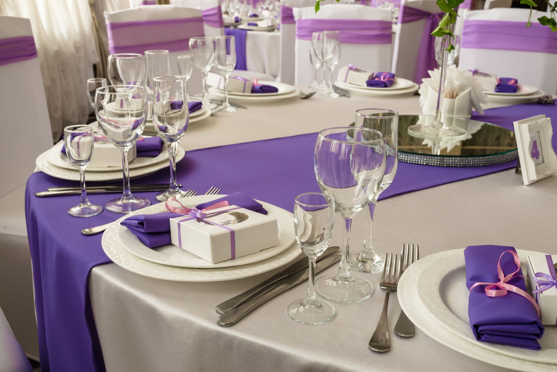 Formal table setting with white tablecloth, purple runner, and matching napkins, ready for a special event.
