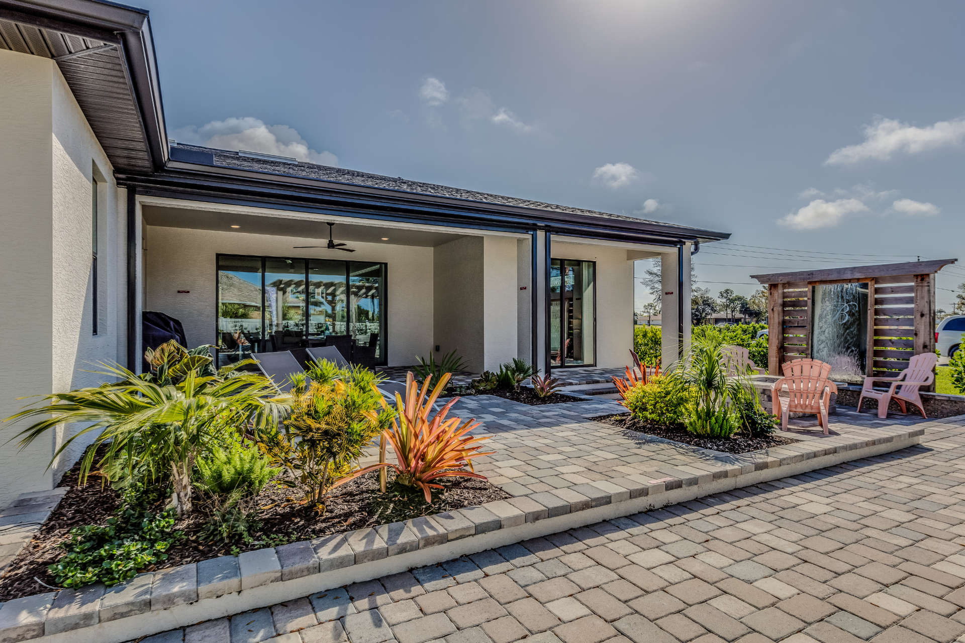 A white house with a patio and chairs in front of it.
