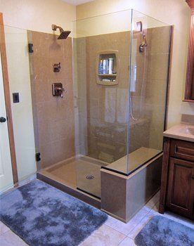 A bathroom with a walk in shower and a sink.
