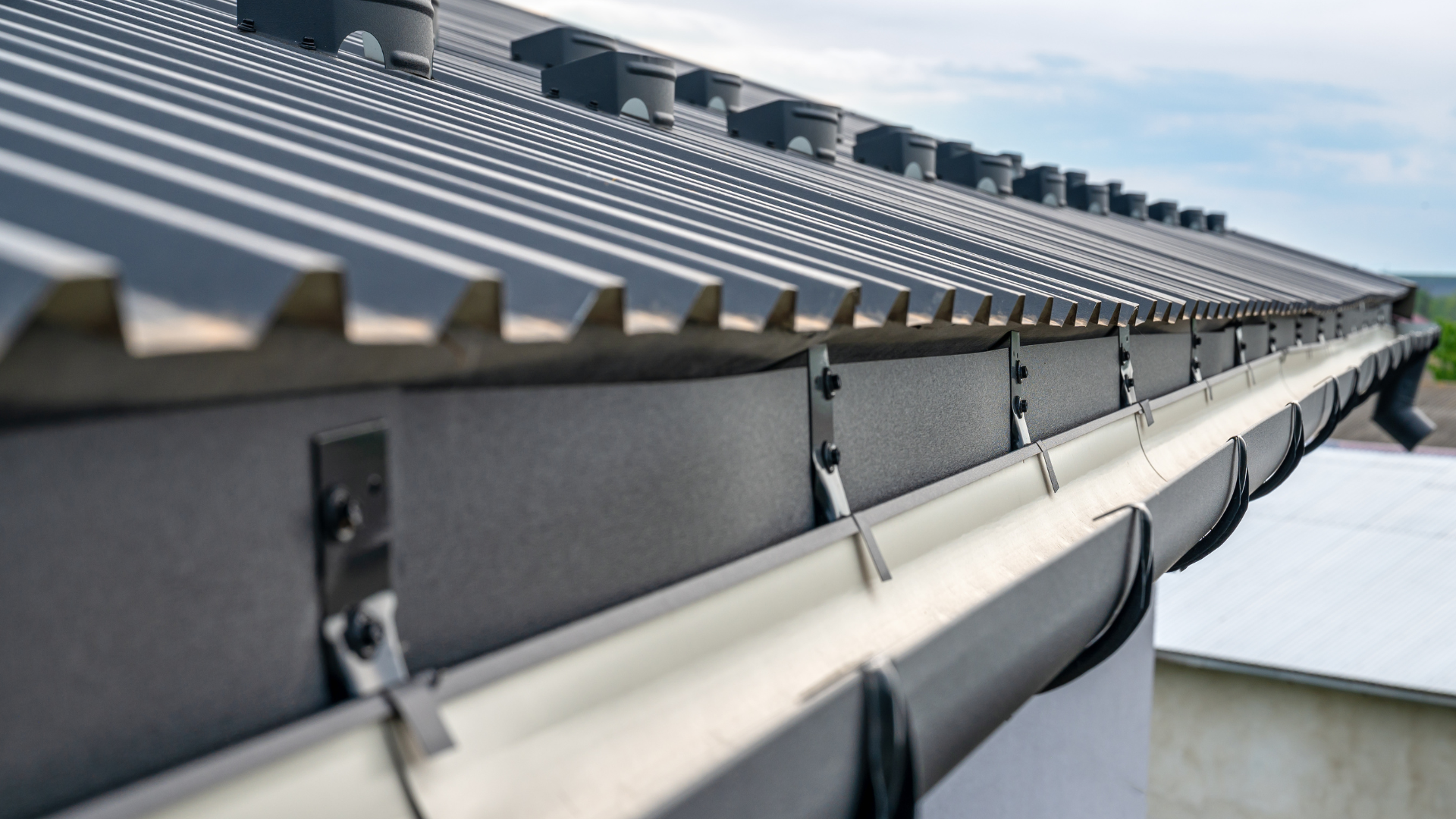 A close up of a gutter on a roof of a building.