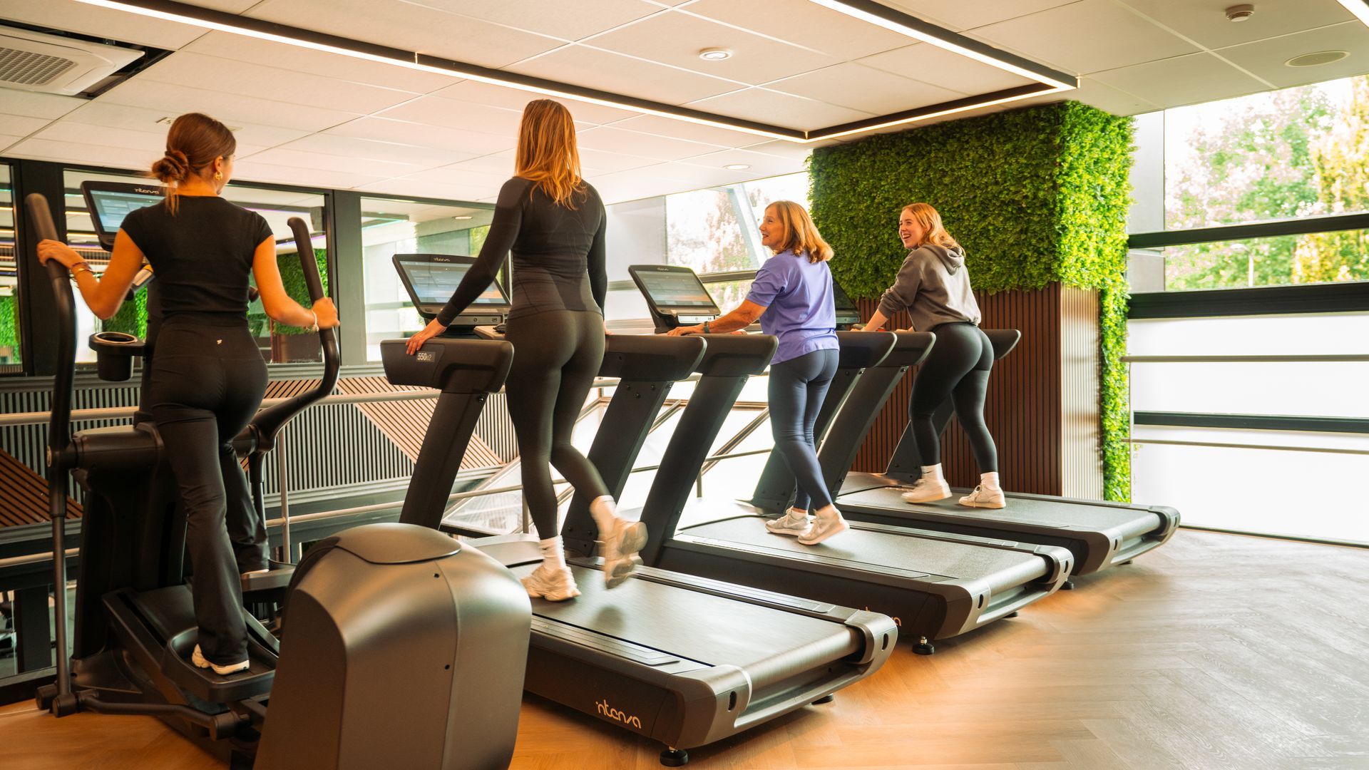 4 Vrouwen op cardio apparatuur in een sportschool.