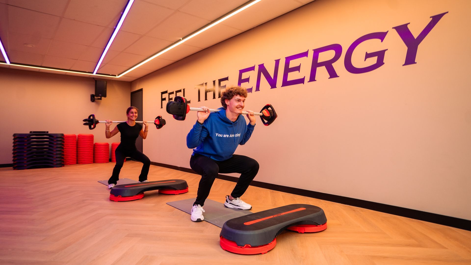 Een persoon tilt een halter op in een sportschool.