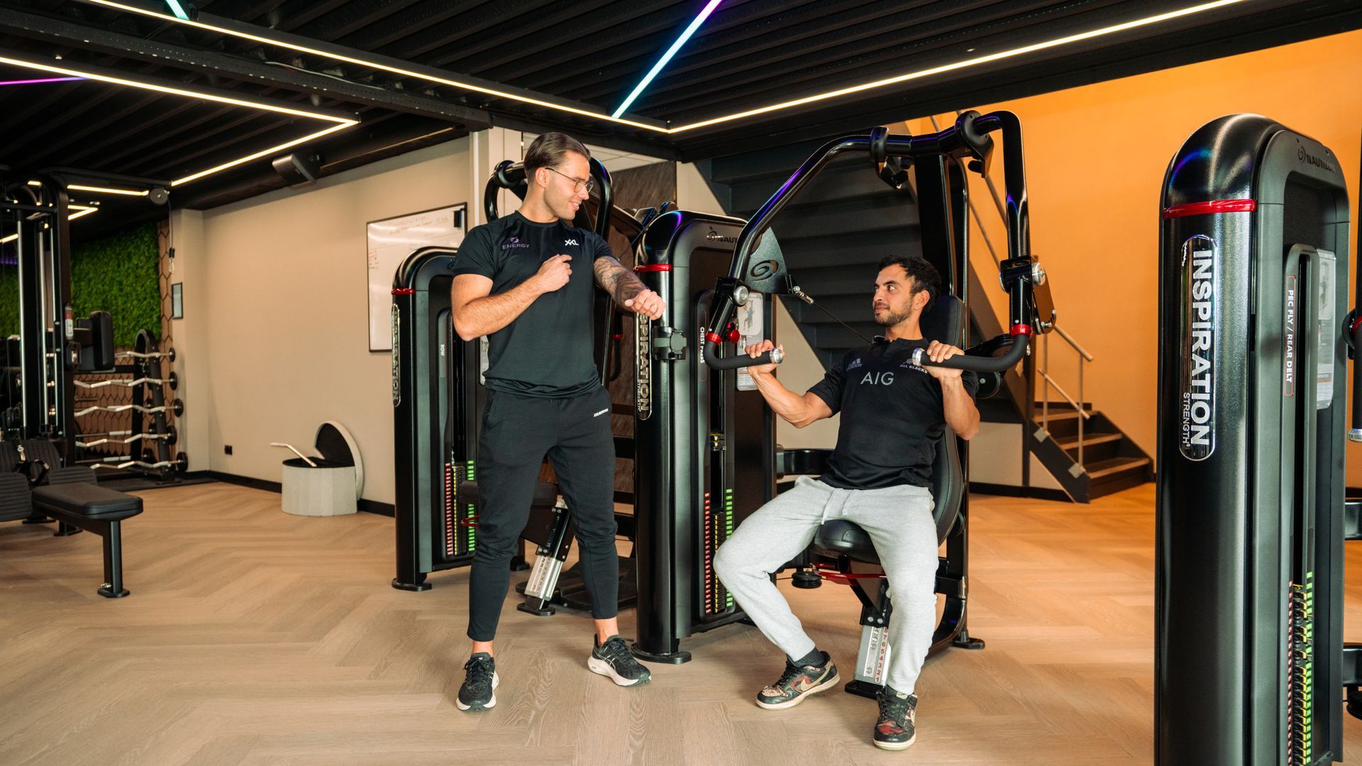 Een groep mensen doet oefeningen met pilatesballen in een sportschool.