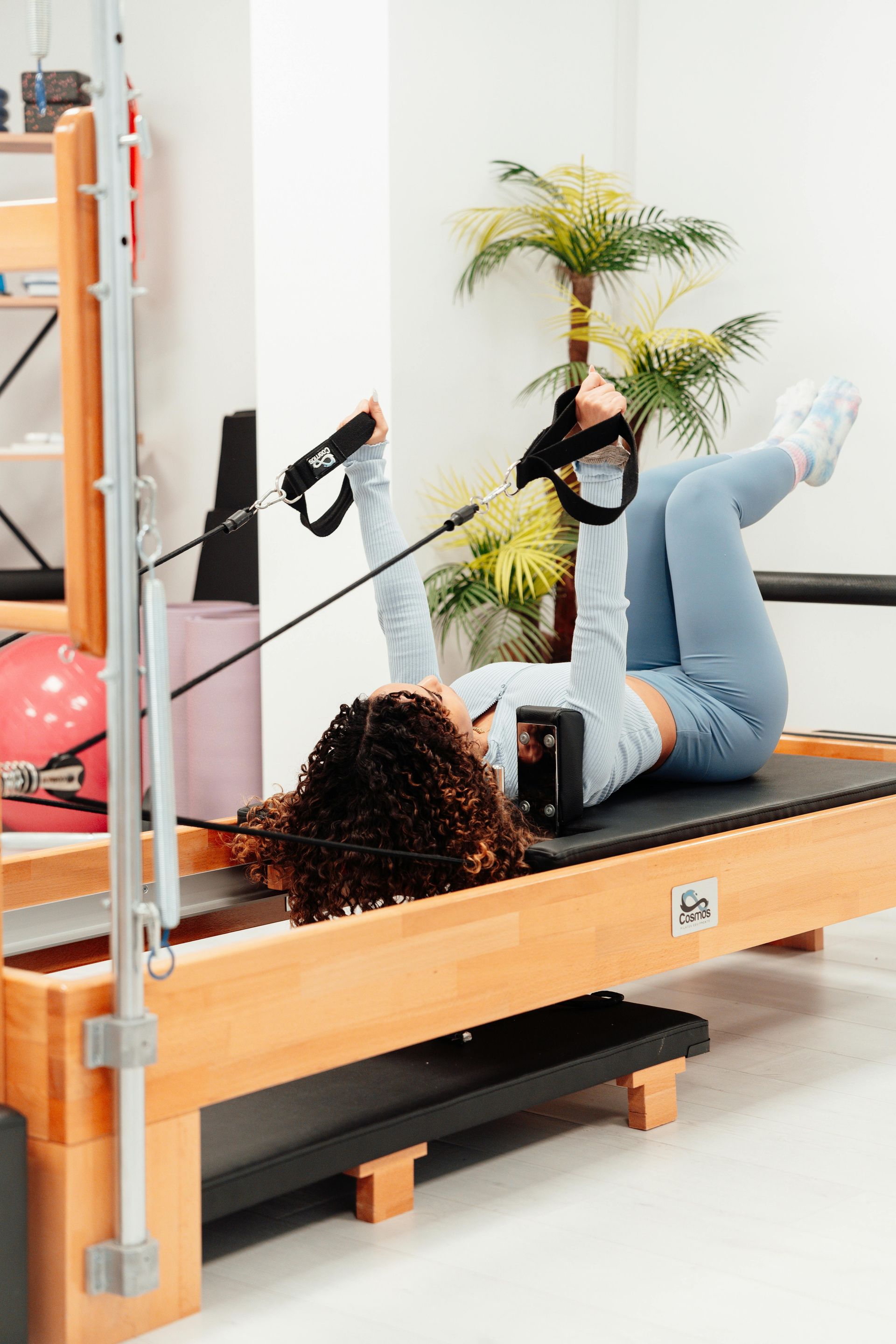 Een vrouw ligt op een pilatesmachine in een sportschool.