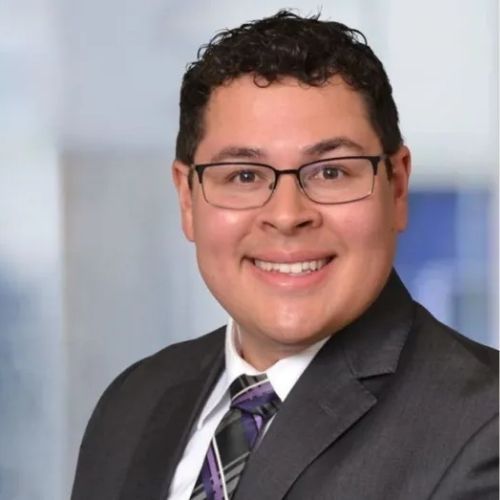 A man in a suit and tie is smiling for the camera