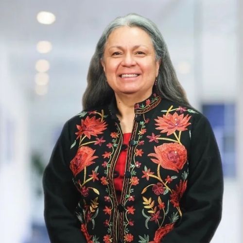 A woman wearing a black jacket with red flowers on it