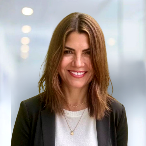 A woman wearing a black jacket and a white shirt is smiling for the camera.