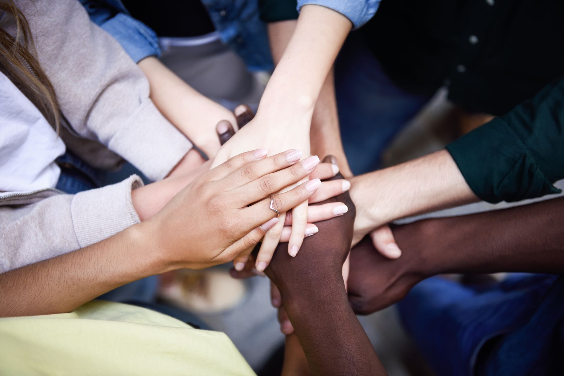 A group of people are putting their hands together.