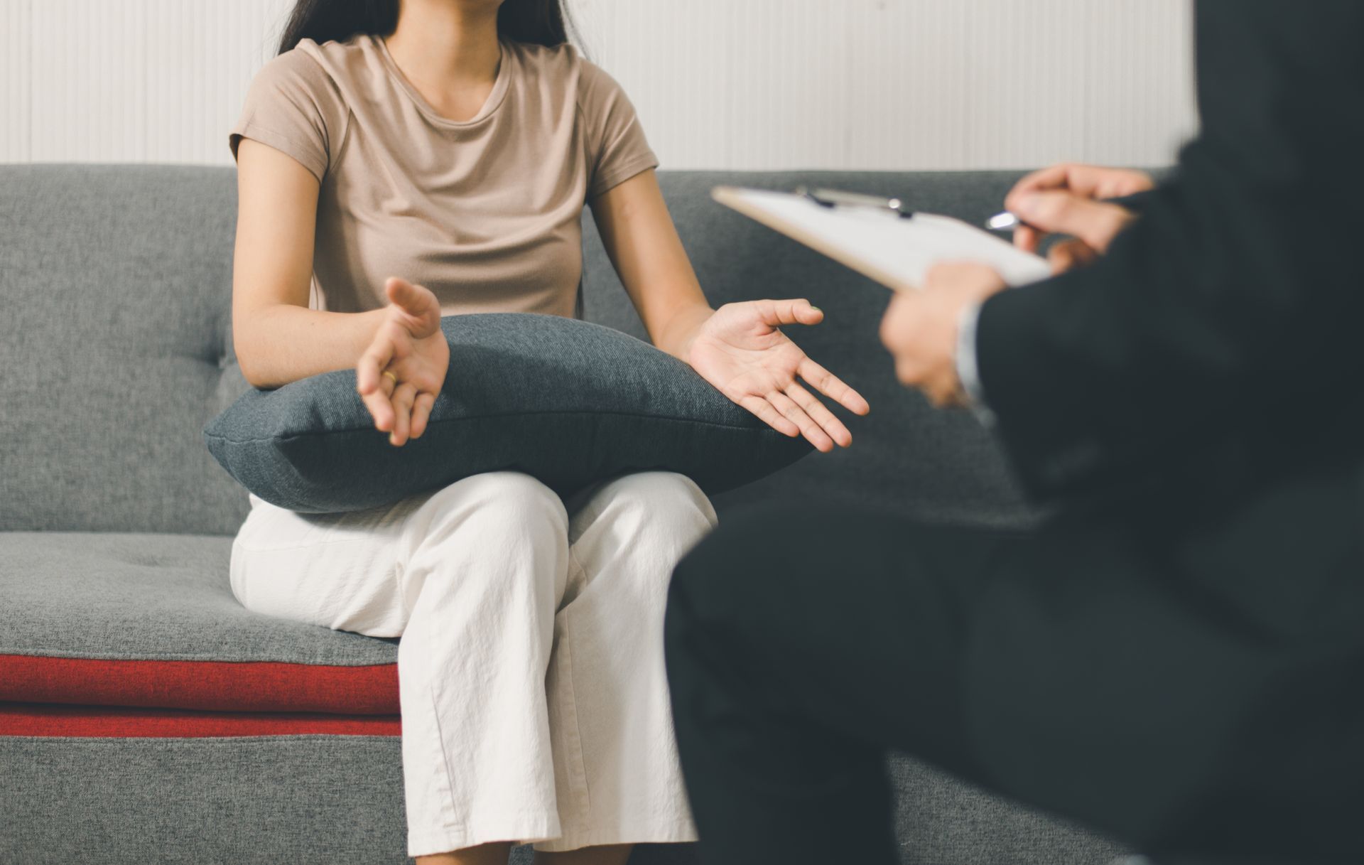 A woman is sitting on a couch talking to a man.