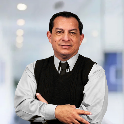 A man with his arms crossed wearing a black vest and tie