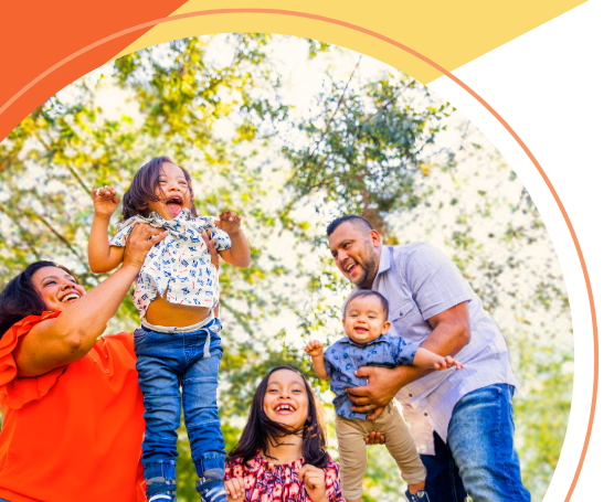 A family is standing next to each other in a park.