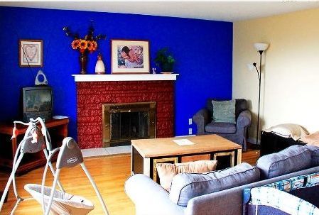 A living room with blue walls and a fireplace