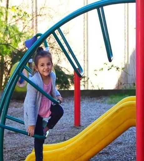 A little girl is playing on a slide at a playground