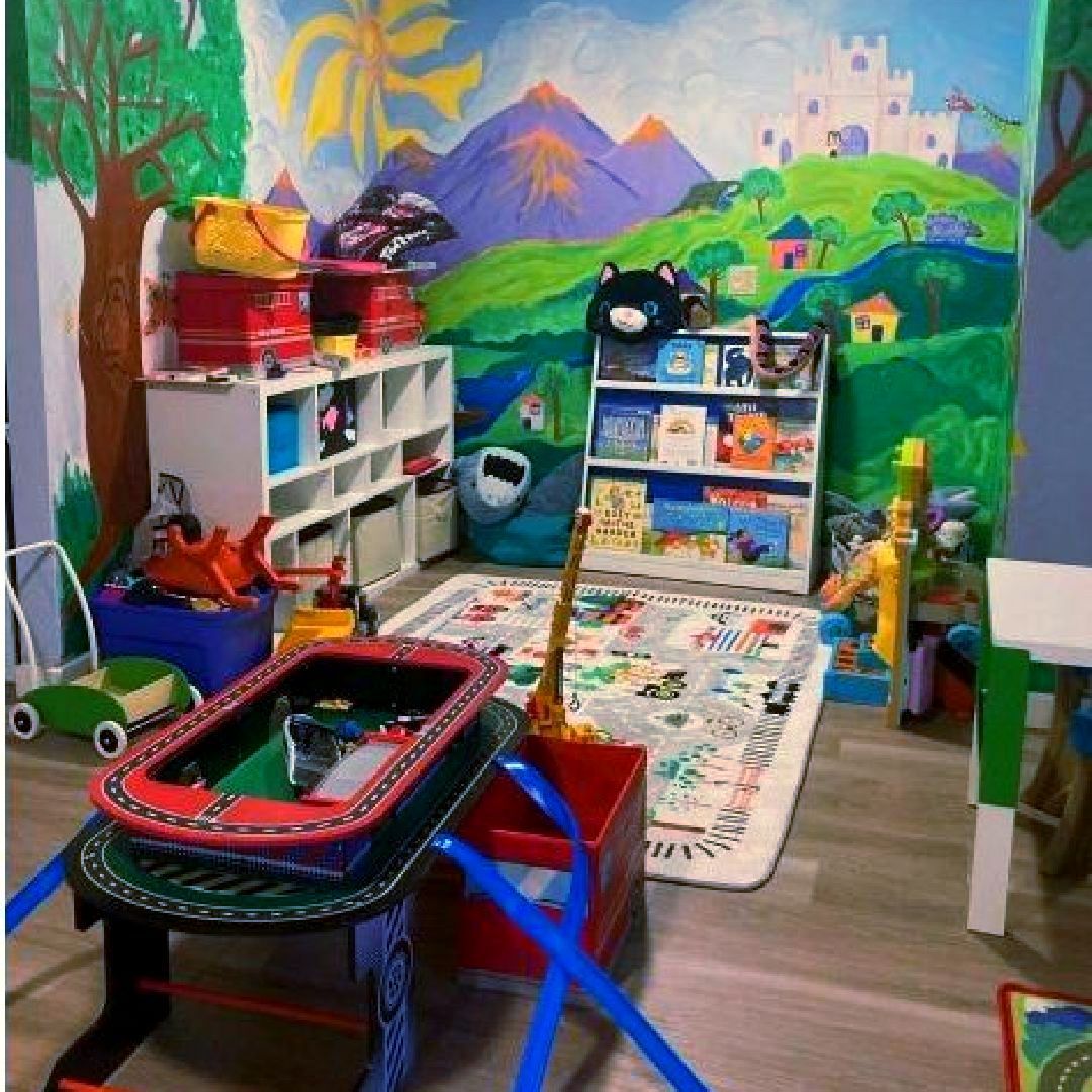 A room filled with lots of toys and a painting on the wall