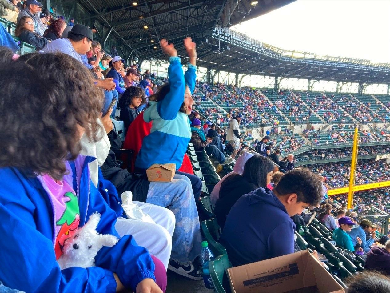 A group of people are sitting in a stadium watching a baseball game.