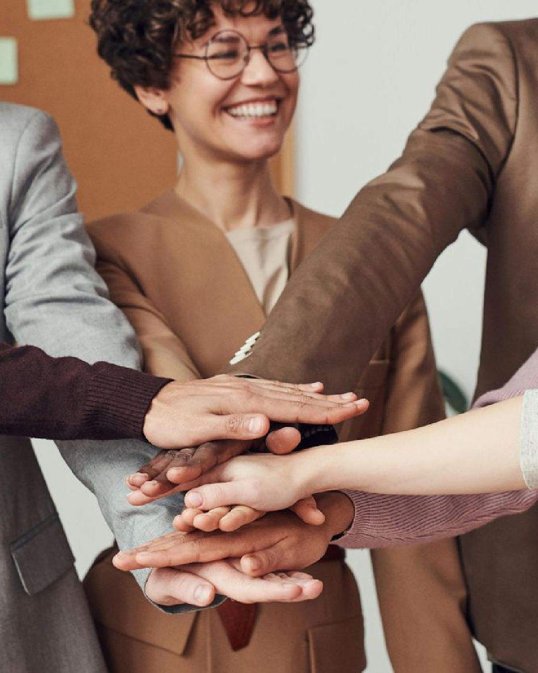 A group of people are putting their hands together