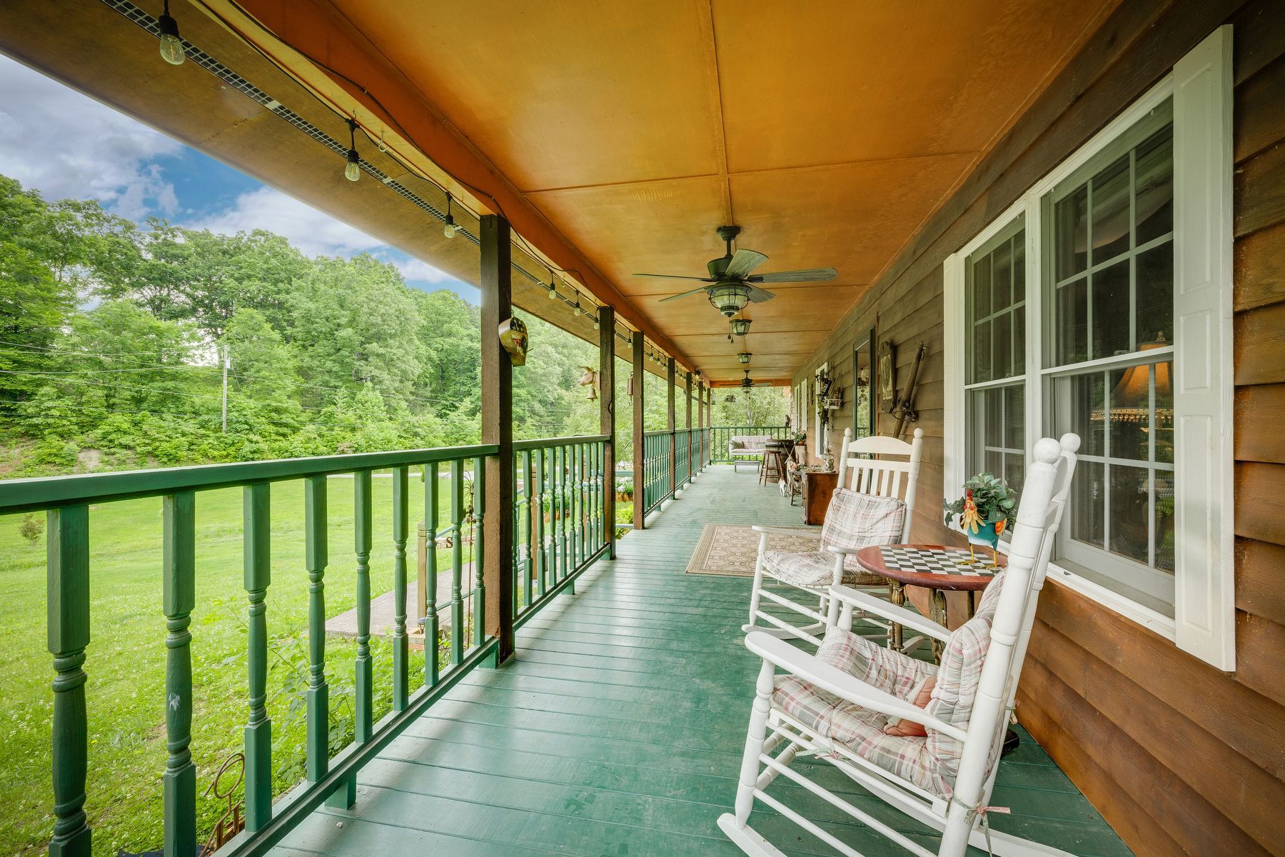 Two rocking chairs on the porch of a house.