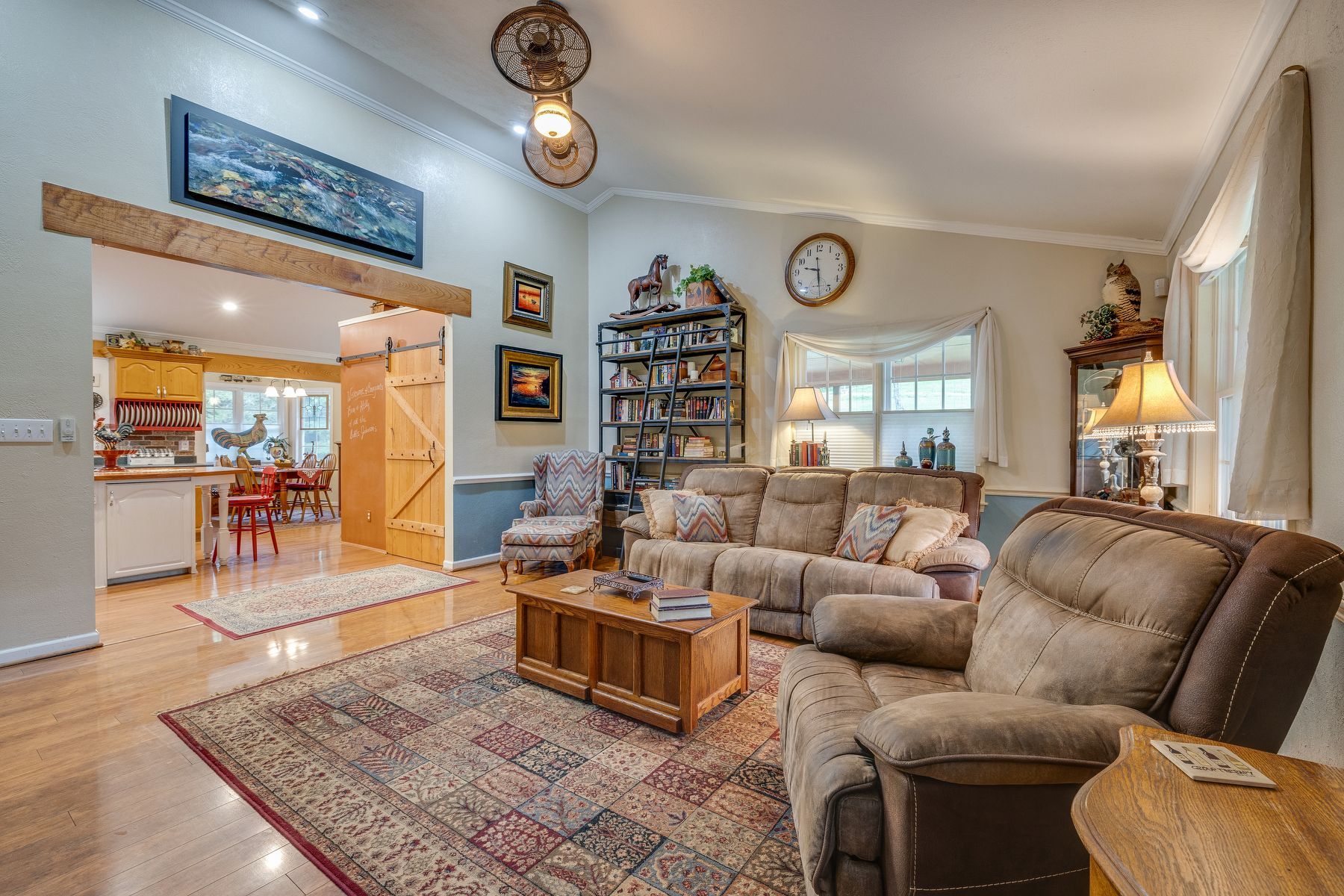 Living room with a couch , chairs , coffee table and rug.