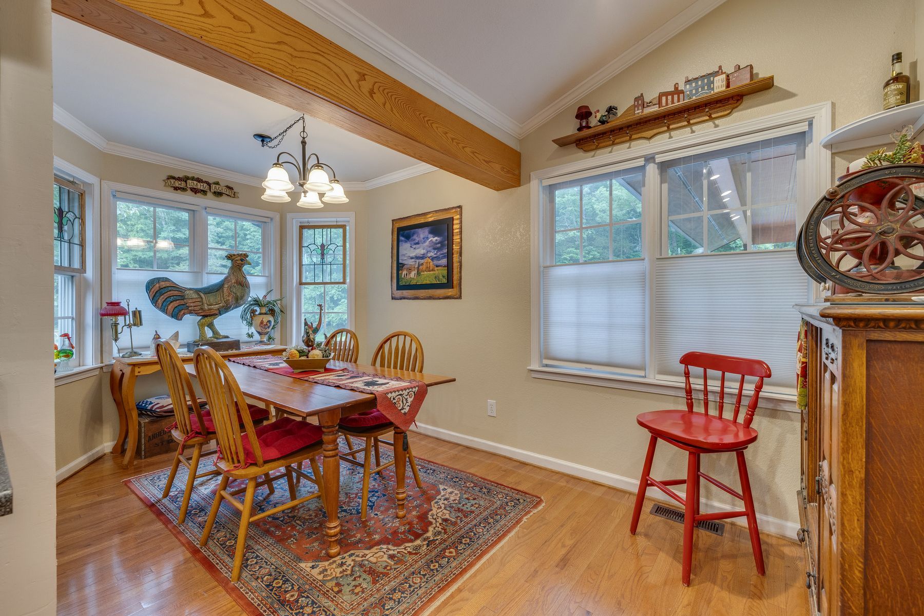 Dining room with a table and chairs and a red chair.