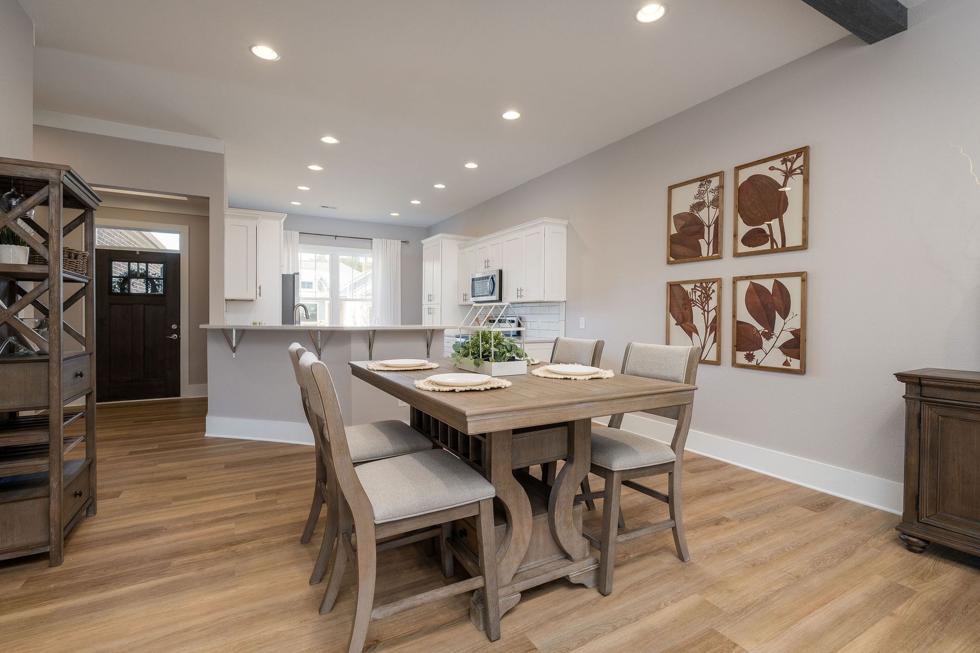 A dining room with a wooden table and chairs in a house.