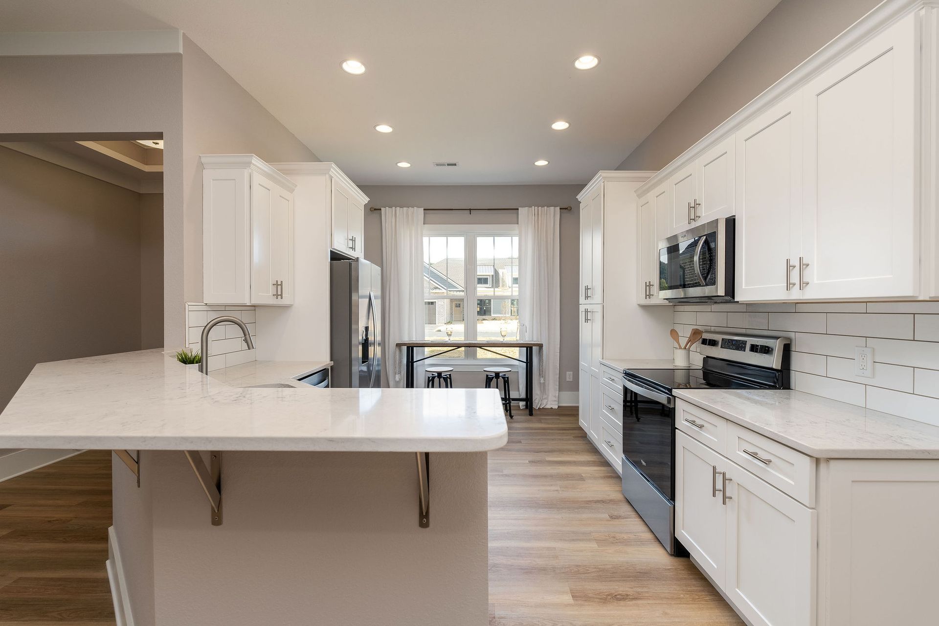 A kitchen with white cabinets and stainless steel appliances.