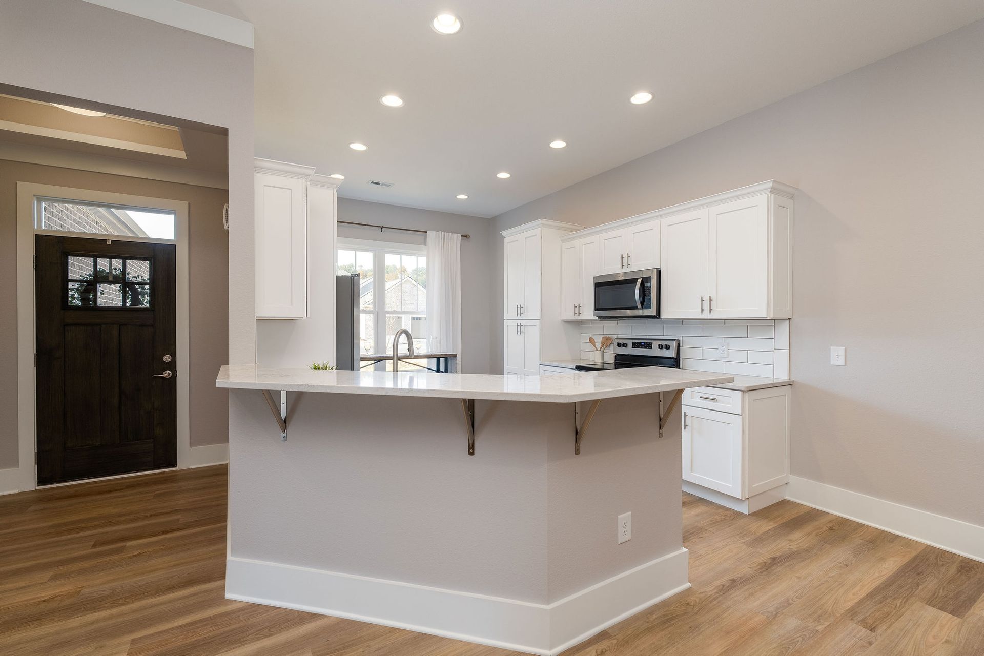 A kitchen with white cabinets and a large island in the middle of the room.