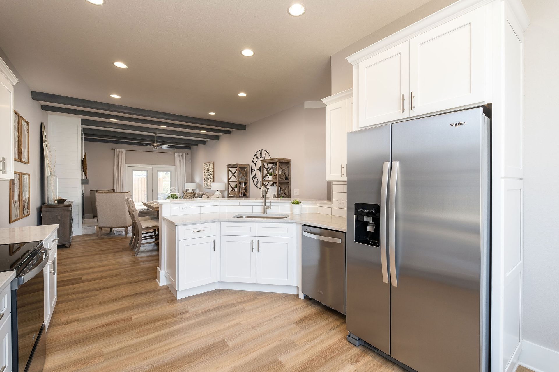 A kitchen with stainless steel appliances and white cabinets.