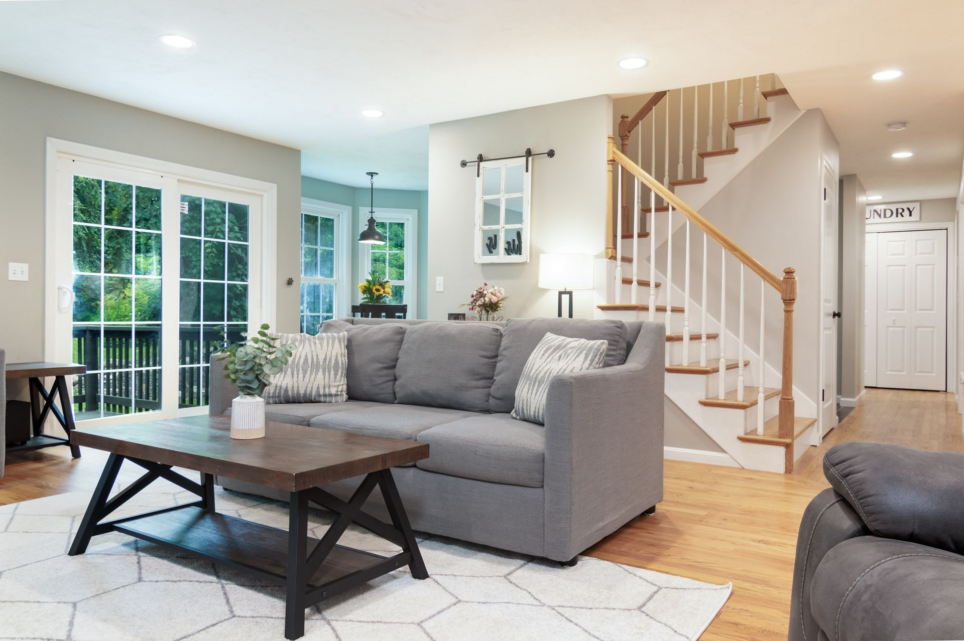 A living room with a couch , coffee table , and stairs.
