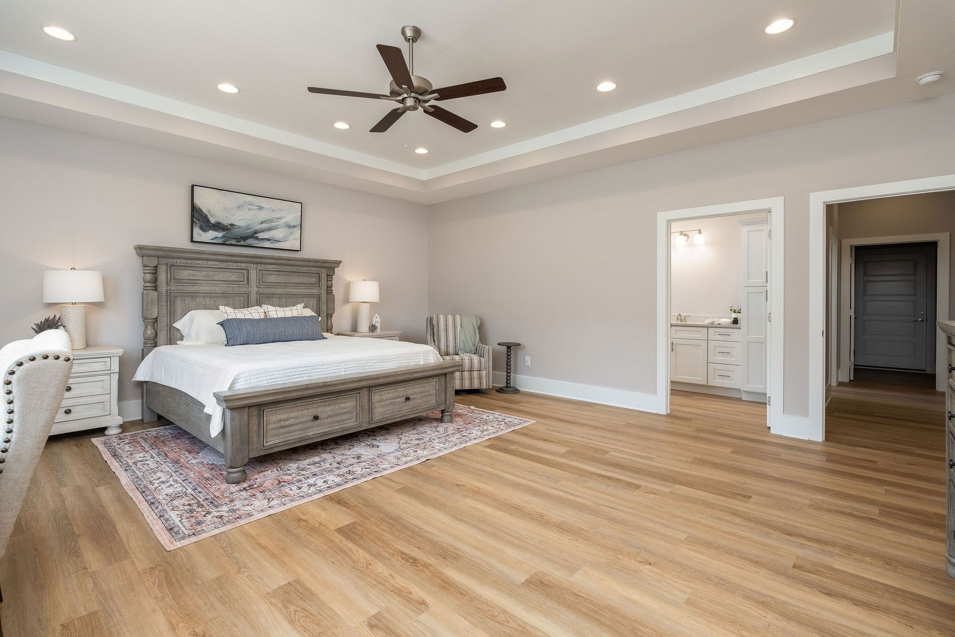 A bedroom with a large bed and a ceiling fan.