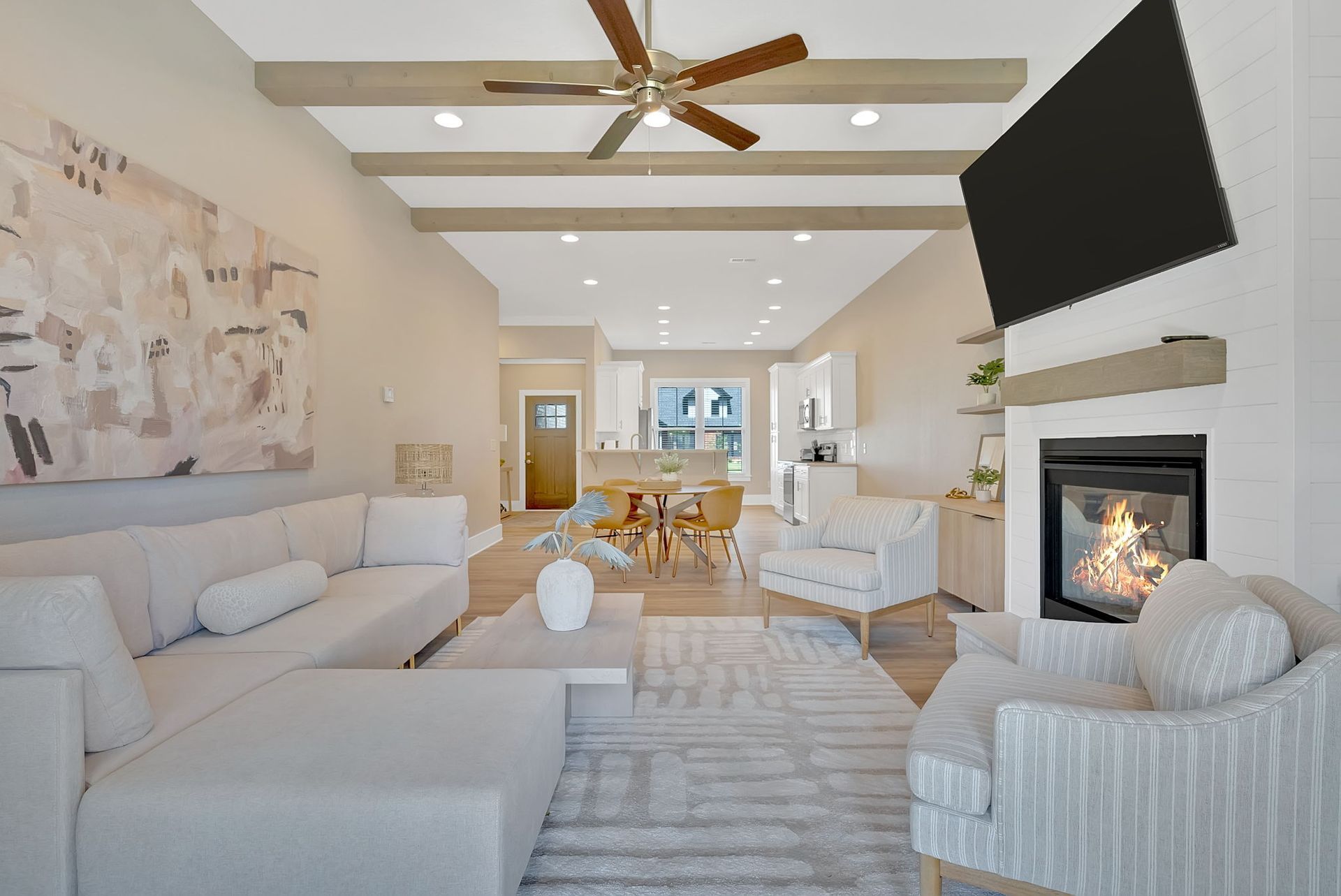 A living room with a couch , chair , fireplace and television.