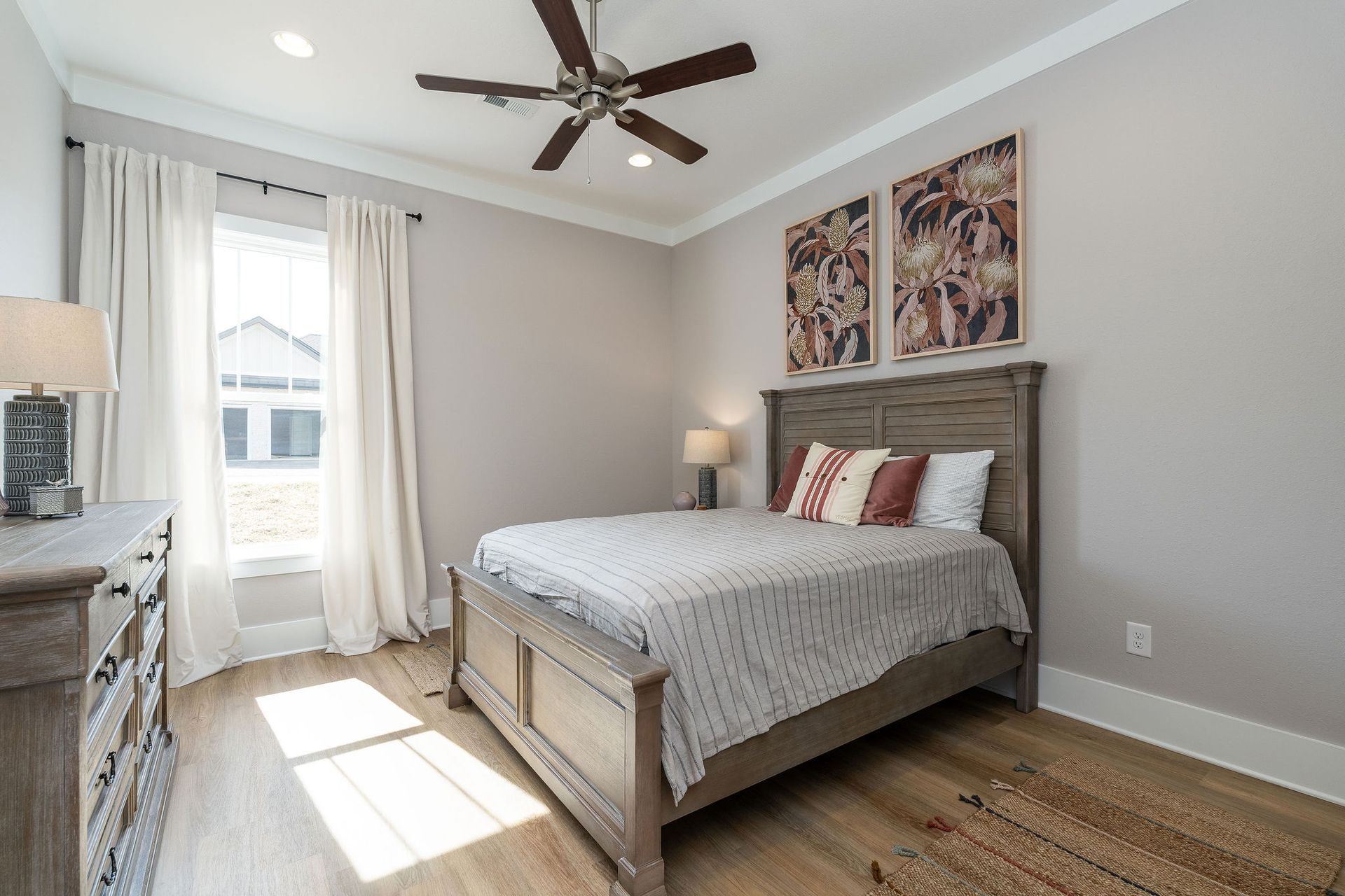 A bedroom with a large bed and a ceiling fan.