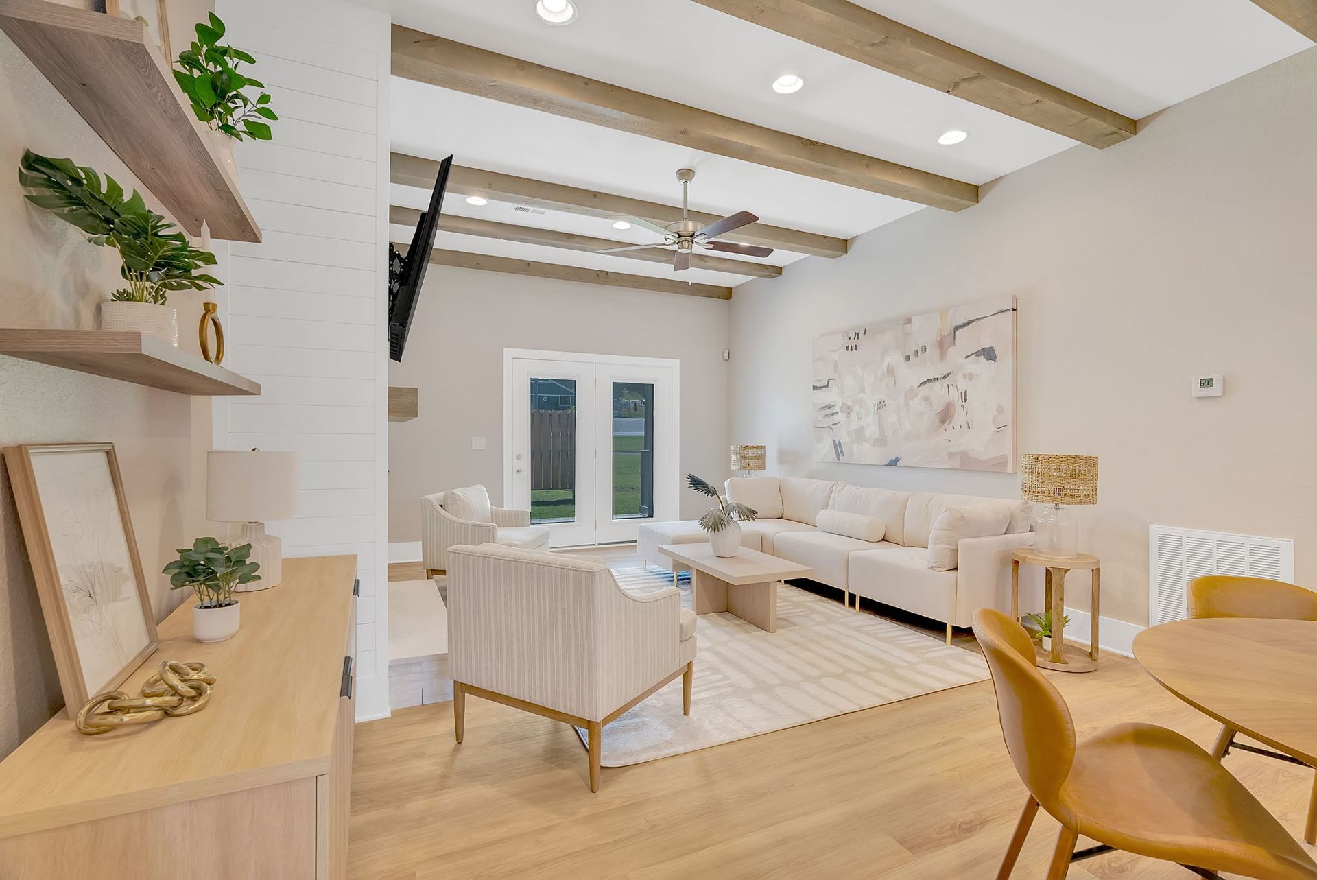 A living room with a couch , chairs , a table and a ceiling fan.