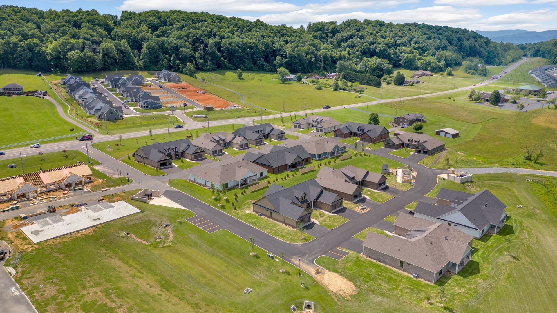 An aerial view of a residential area with lots of houses and trees in the background.