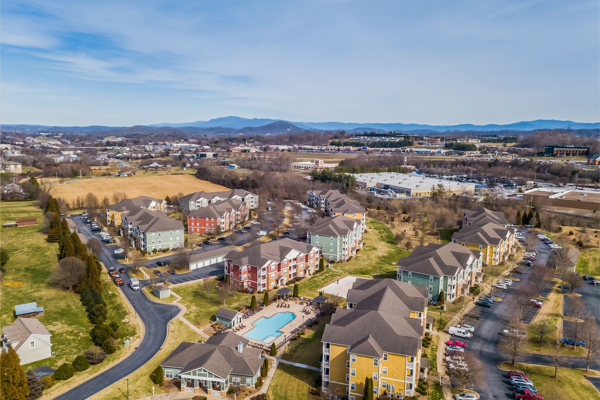 Aerial view of a residential area in Johnson City with a pool and mountains in the background.