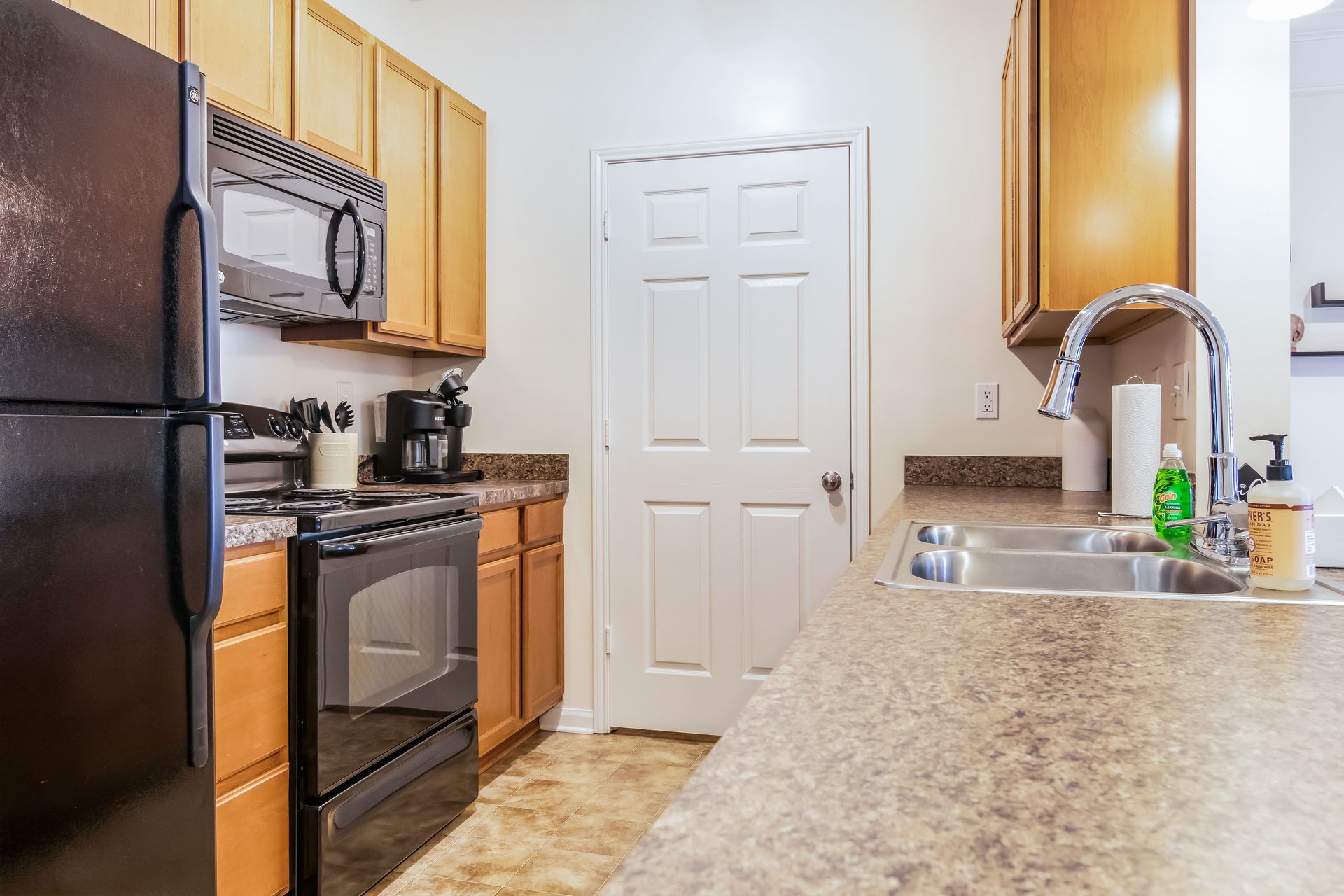 Kitchen with a black refrigerator , stove , microwave , sink and cabinets in Johnson City