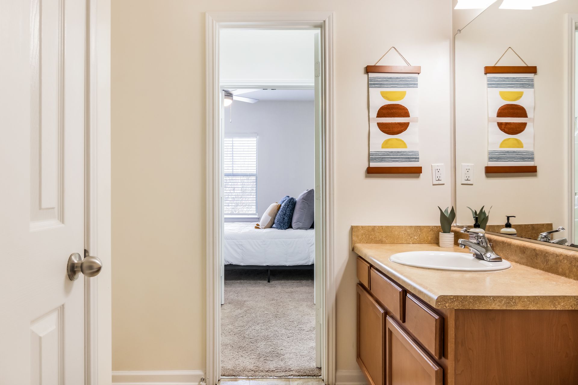 Bathroom with a sink , mirror and door leading to a bedroom in Johnson City