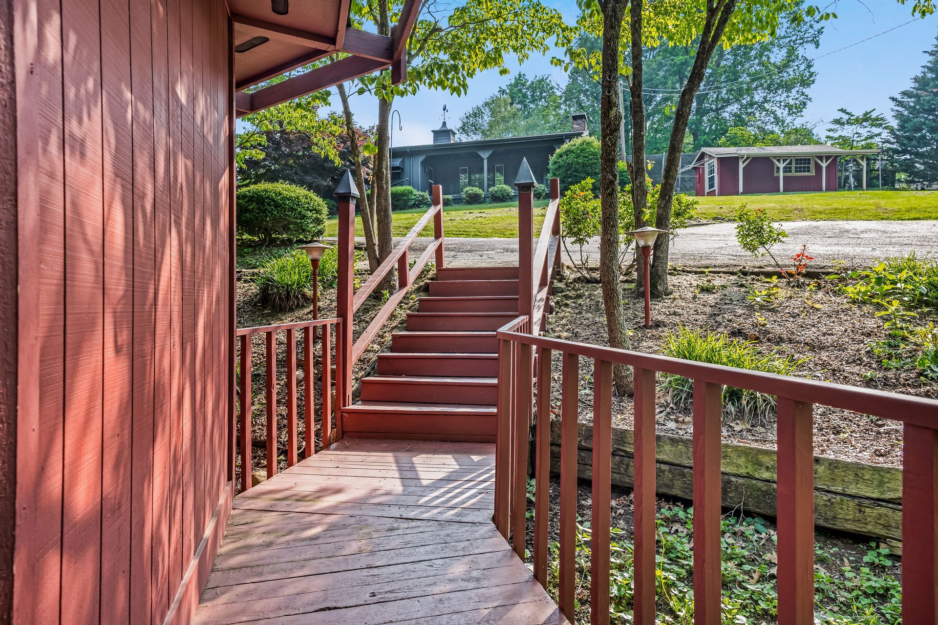 A wooden deck with stairs leading up to a house.