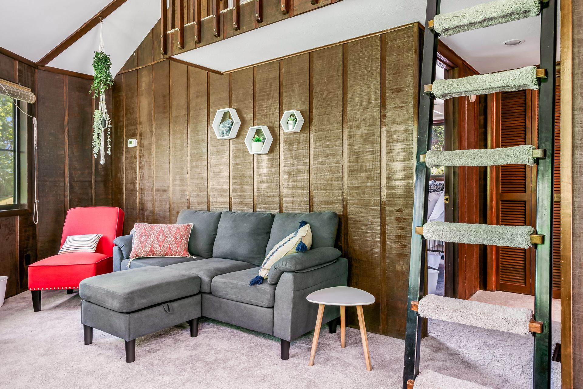 A living room with a couch , chairs , and a ladder.