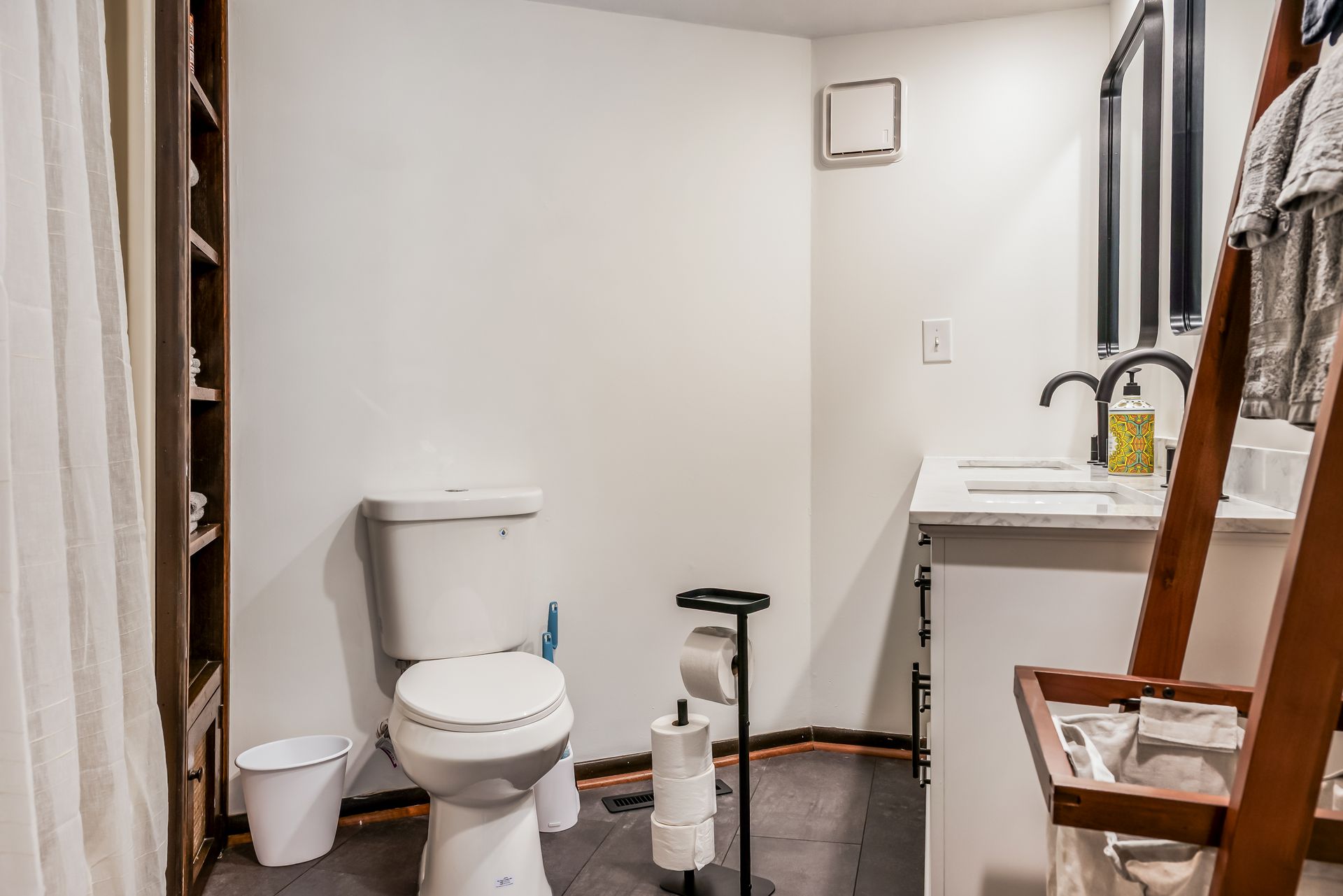 A bathroom with a toilet , sink , and shower curtain.