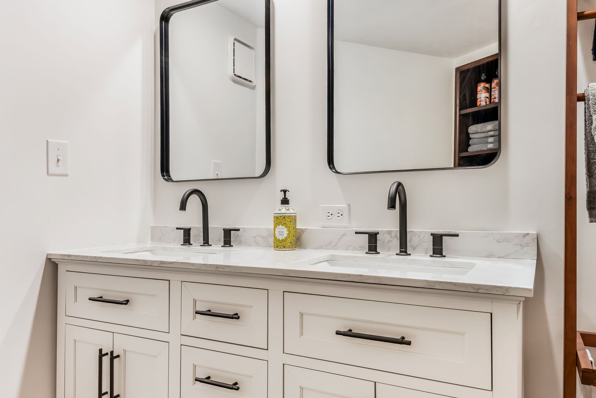 A bathroom with two sinks and two mirrors.