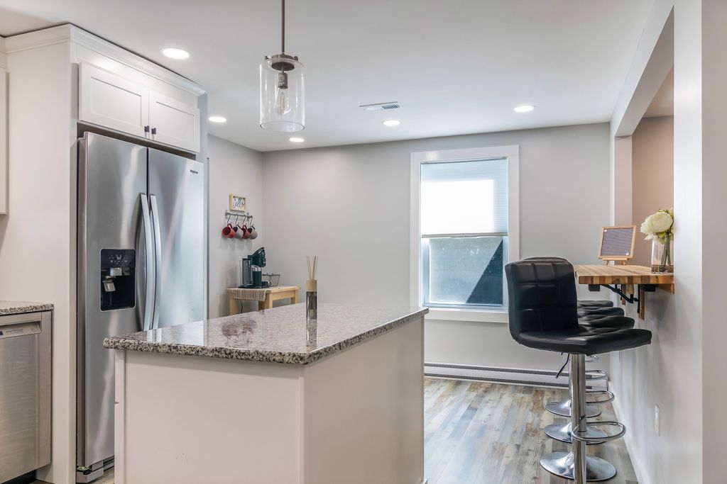 Kitchen fully stocked, with a stainless steel refrigerator and a granite counter top in Mystic, CT